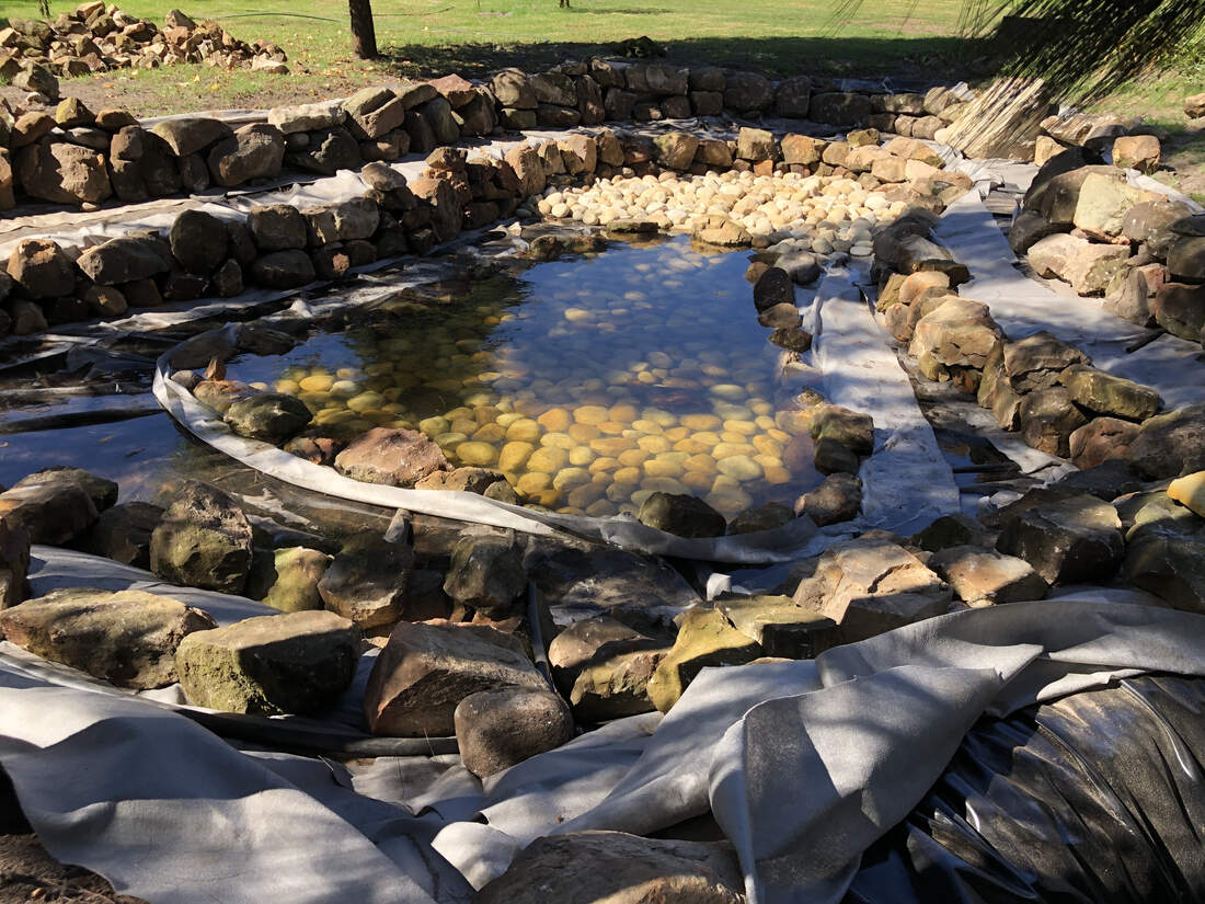 Close-up of the pebbled pond floor and stone edging