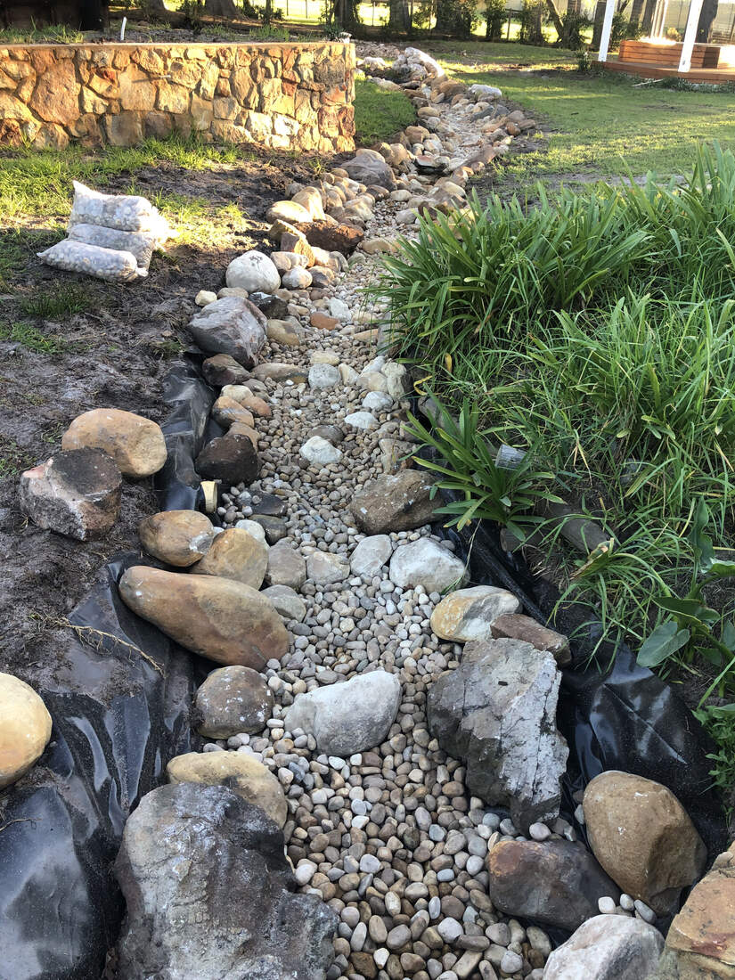 The pebbled stream channel feeding the pond