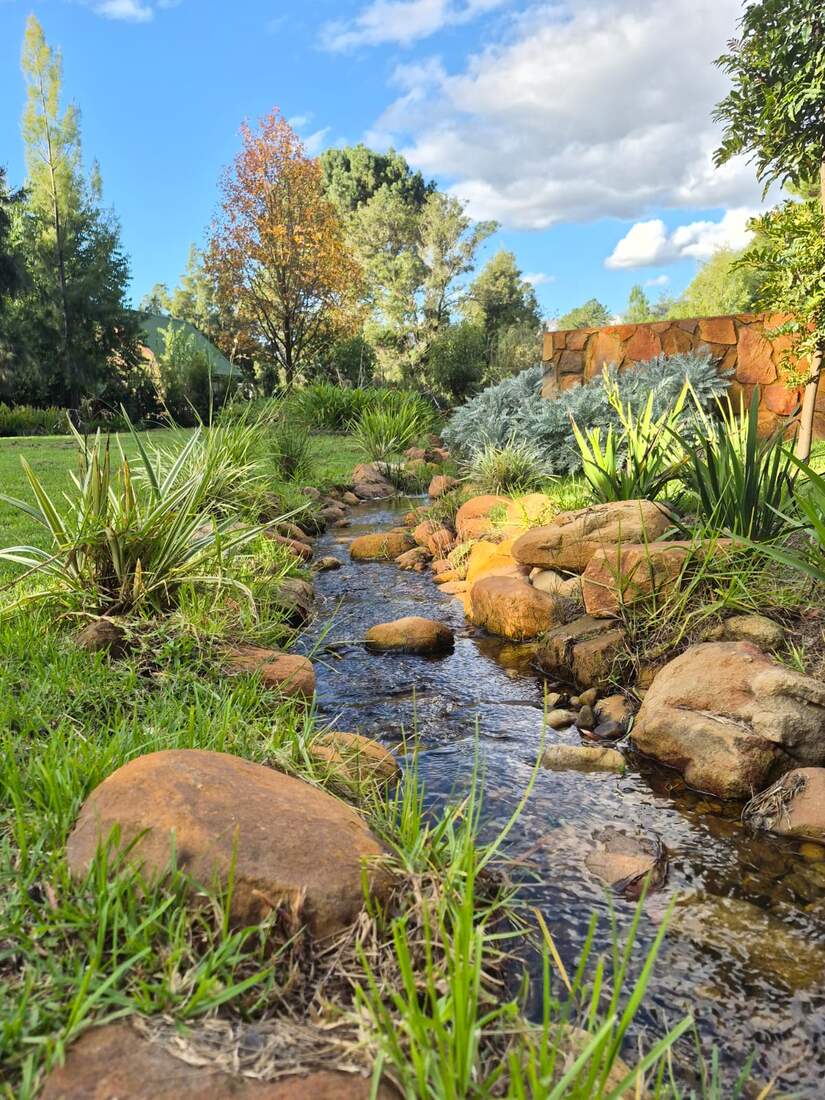 The finished stream, with water flowing over the pebbles